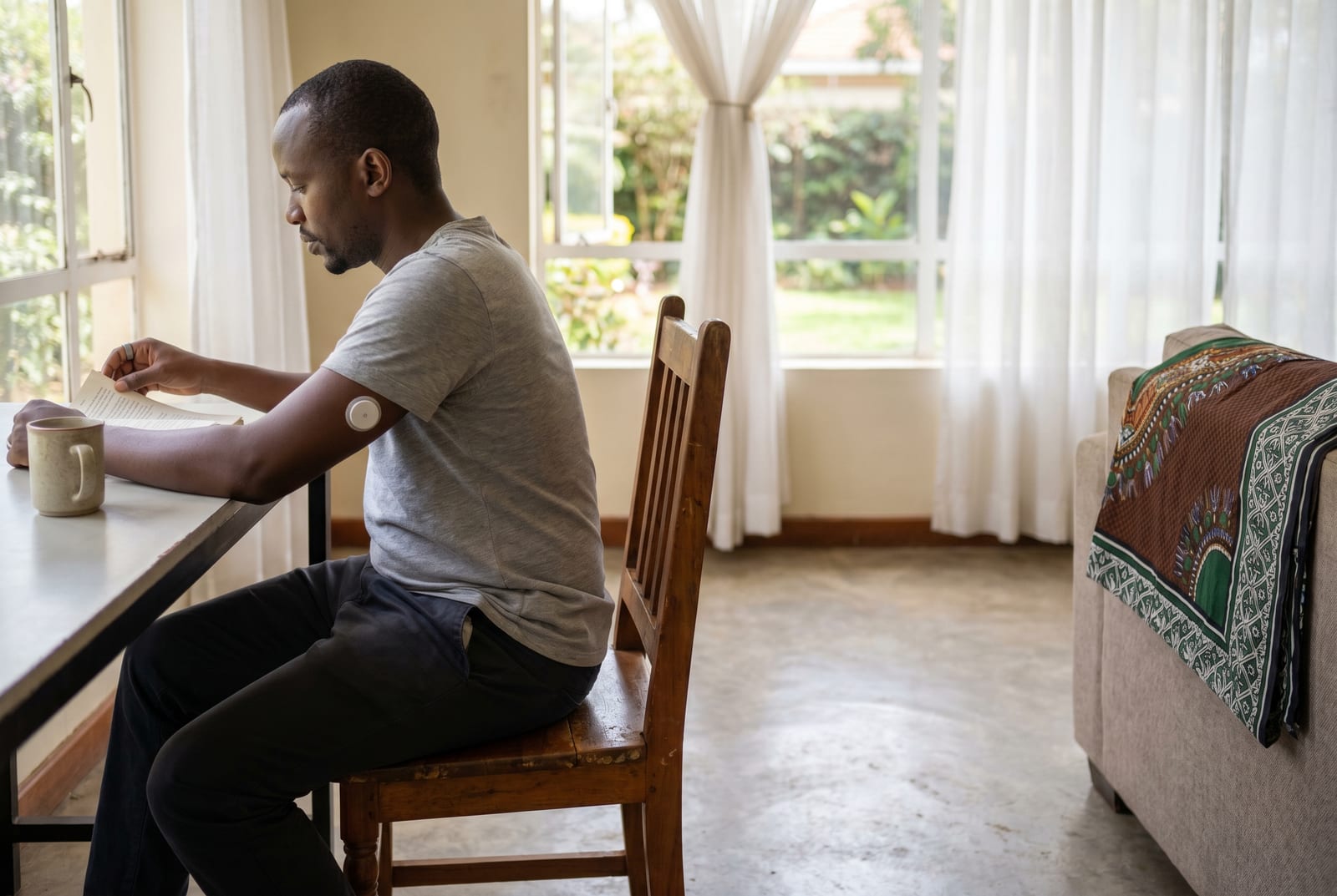 Mwanaume kwenye meza ya chakula cha mchana, akila, marafiki nyuma yake - Imetengenezwa na AI